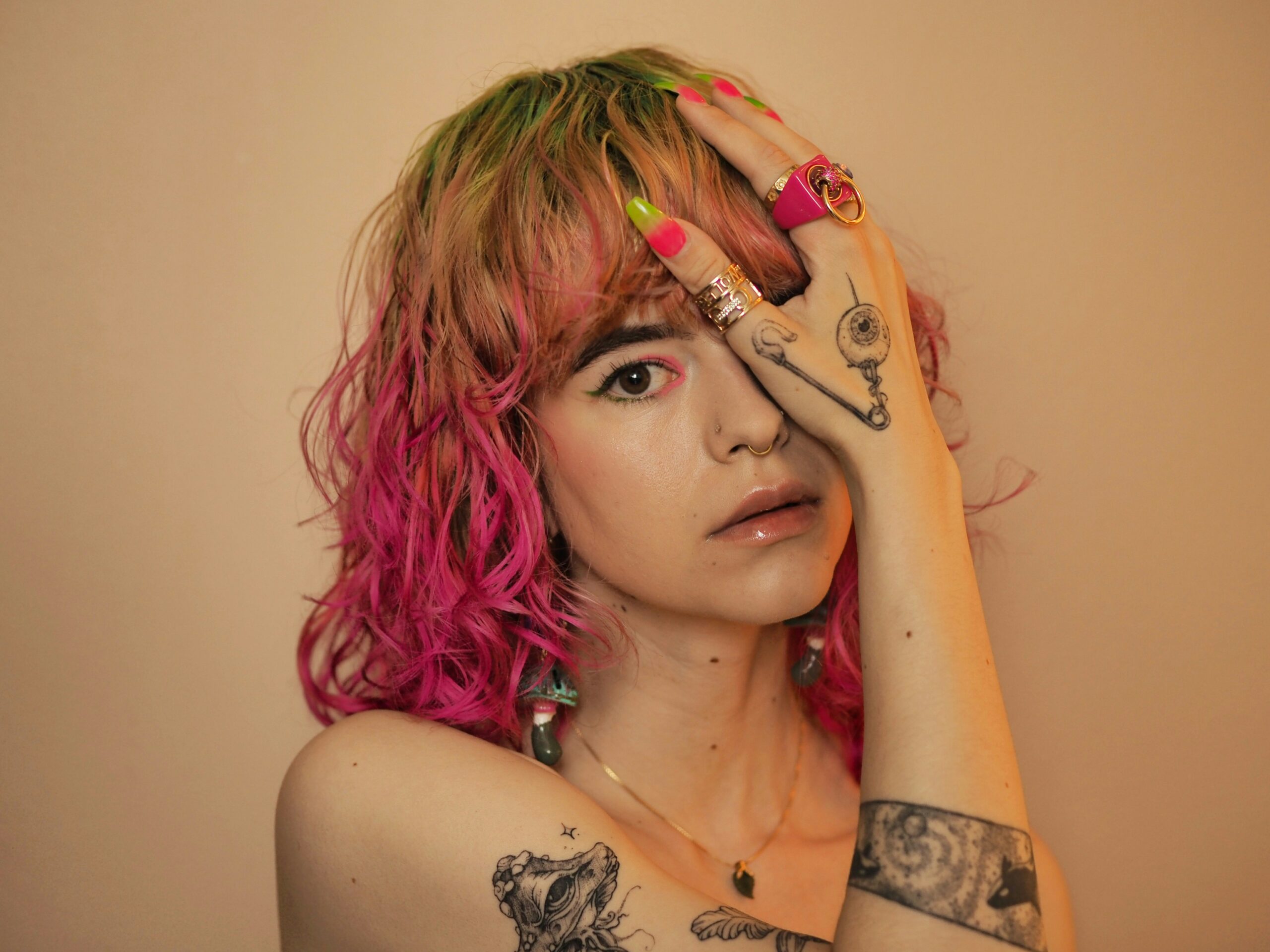 κοπέλα με τατουάζ, σκουλαρίκια και πολύχρωμα μαλλιά