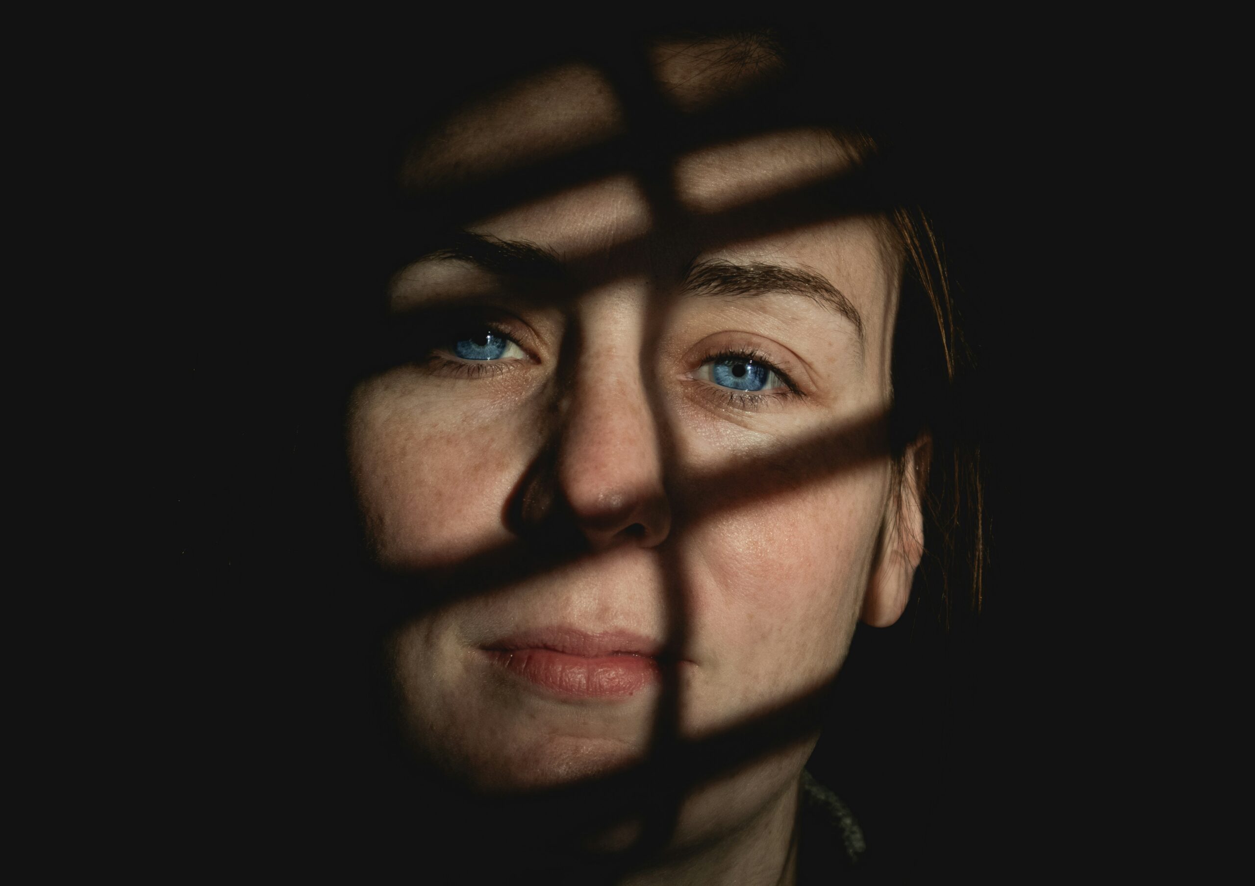 Γυναίκα με μπλε μάτια και σκιές στο πρόσωπό της