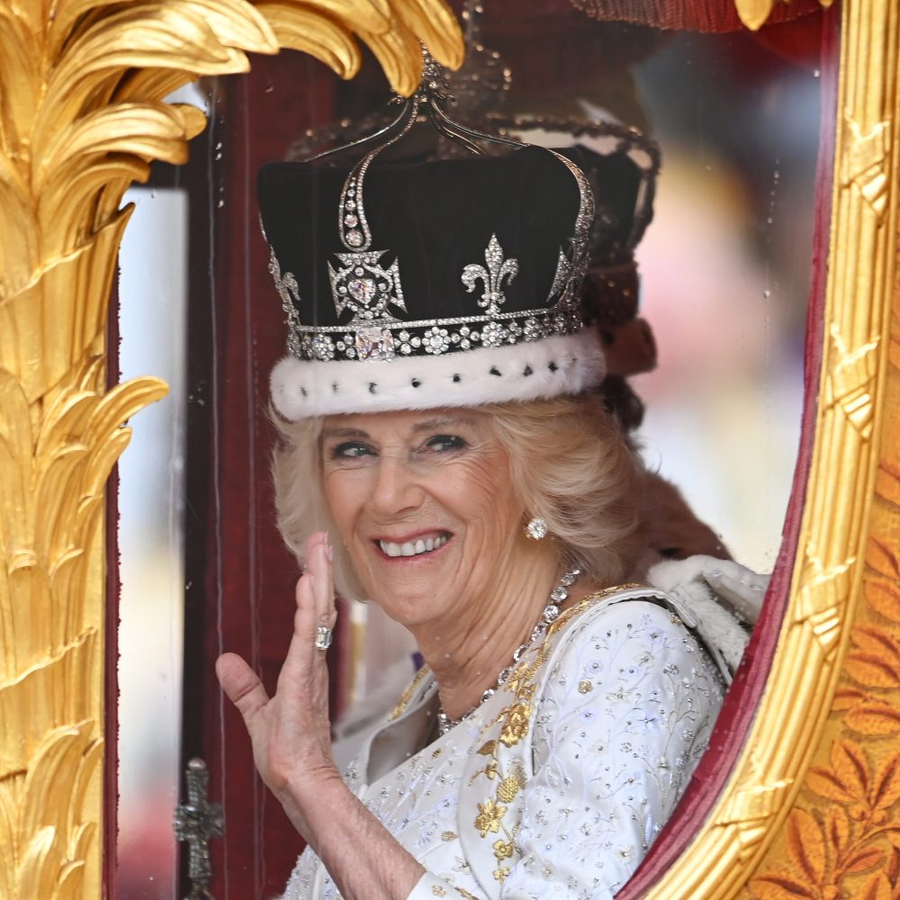 epa10611838 Britain's Queen Camilla wearing a modified Queen Mary's crown smiles and waves as she sits in the Golden State Coach after Britain's King Charles III and her Coronation at Westminster Abbey, London, Britain, 06 May 2023. Coronations of British Kings and Queens have taken place at Westminster Abbey for the last 900 years. The service was attended by around 100 heads of state from around the world.  EPA/Andy Rain