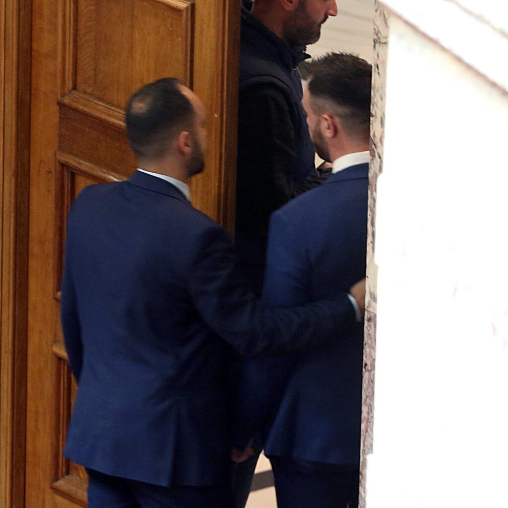 Δύο άντρες βγαίνουν από μία πόρτα στη Βουλή
