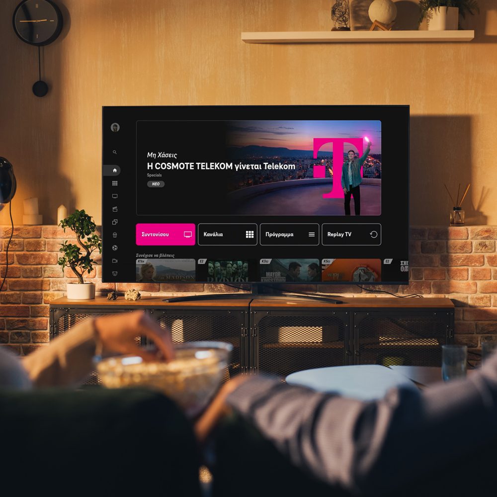 Authentic Couple Spending Time at Home, Sitting on a Couch and Watching Latest Blockbuster on Flat Screen Television Set. Man and Woman Streaming Movie or Show Using Home Cinema System.