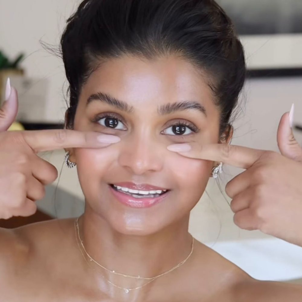 Γυναίκα ακουμπάει τα δύο της δάχτυλα στο πρόσωπό της