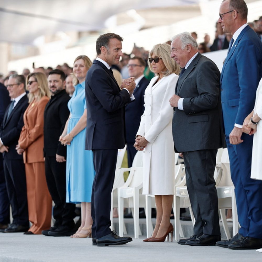 epa13110160 French President Emmanuel Macron (C) greets German Chancellor Friedrich Merz (2-R) and guests from countries of the 'Coalition of the Willing' as Ukraine's President Volodymyr Zelenskiy (5-L) looks during the annual Bastille Day military parade on the Place de la Concorde in Paris, France, 14 July 2026. France's national holiday, or Bastille Day, is celebrated annually on 14 July, with 'The Strategic Awakening of Europe' as this year's theme.  EPA/BENOIT TESSIER / POOL  MAXPPP OUT