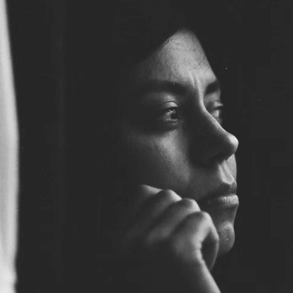 Ασπρόμαυρη εικόνα με γυναίκα που κοιτάζει προς κάποιο παράθυρο