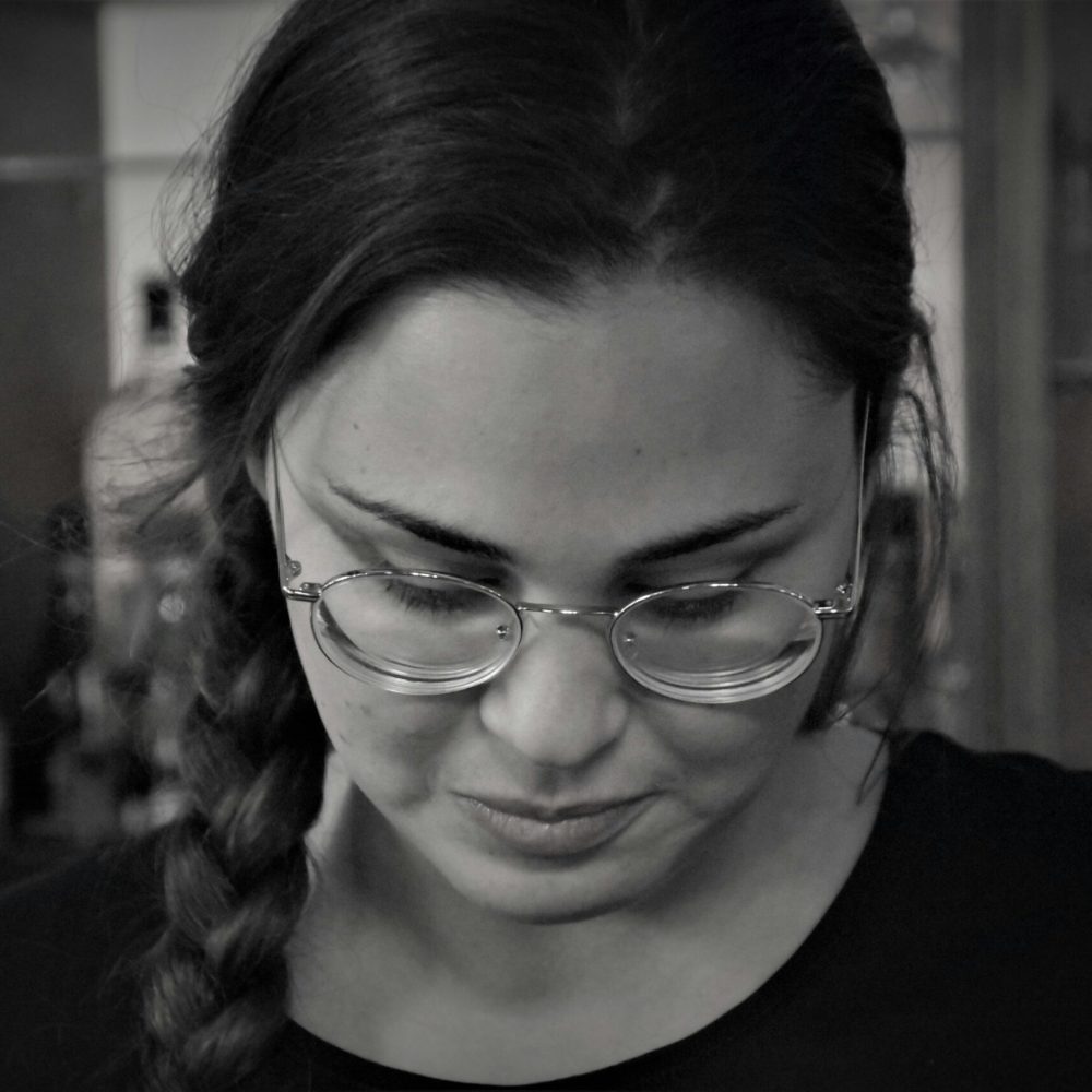 Ασπρόμαυρη εικόνα με γυναίκα που φοράει γυαλιά μυωπίας και κοιτάζει προς τα κάτω
