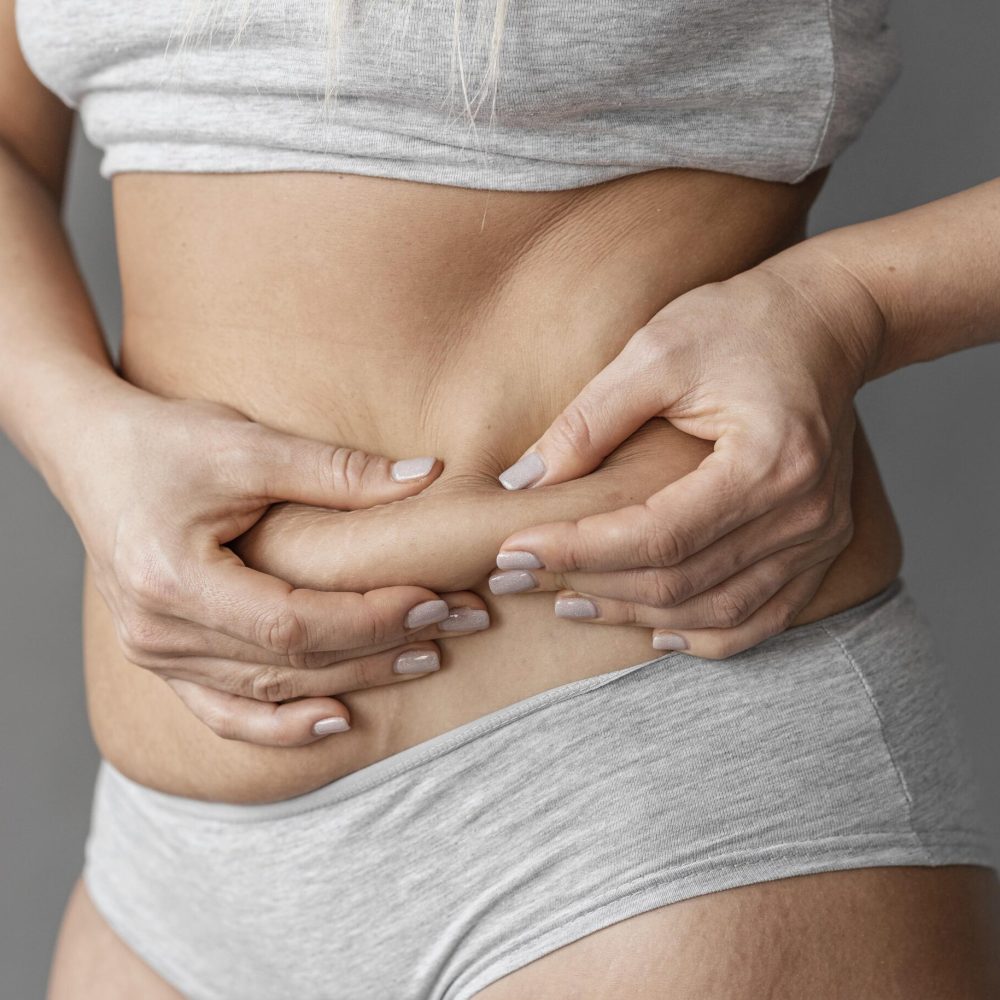 close-up-hands-holding-belly-fat