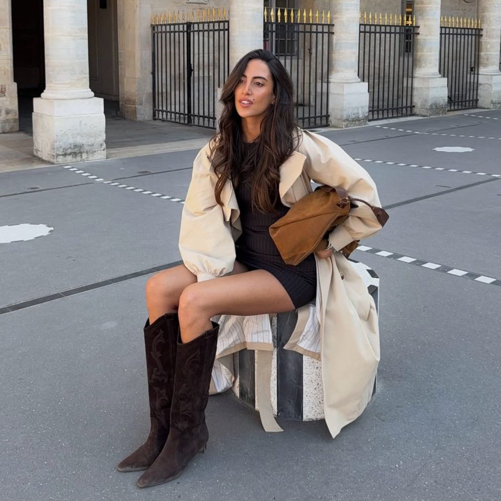 Γυναίκα με μπεζ καμπαρντίνα και καφέ σκούρες καουμπόικες μπότες