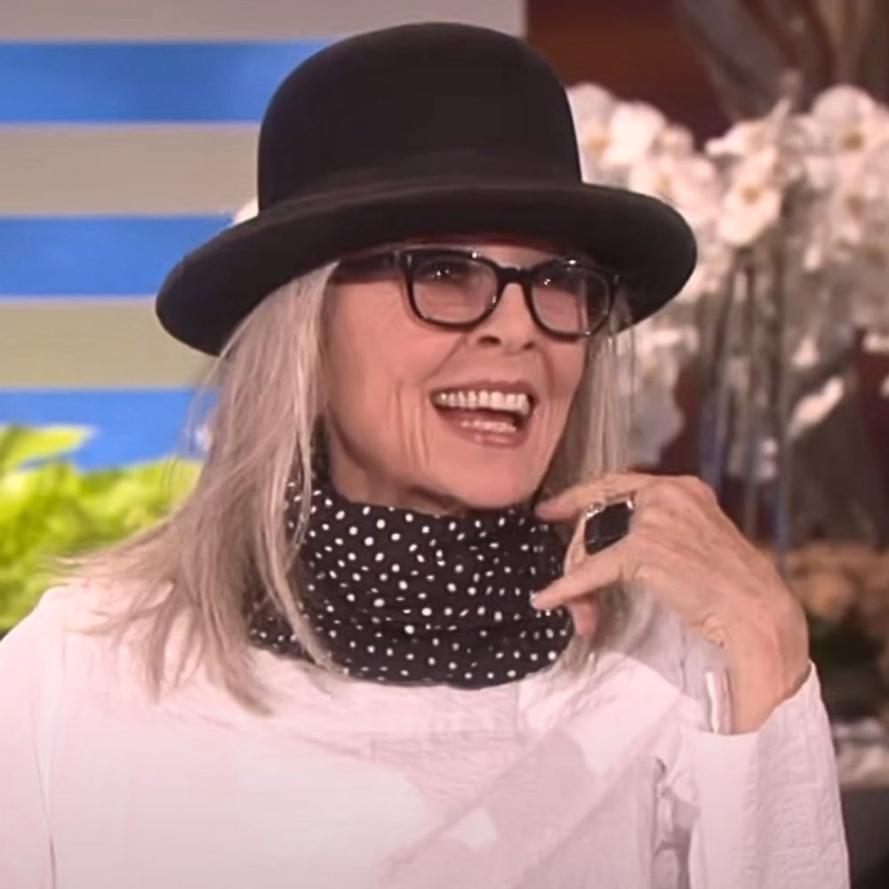 Γυναίκα με μαύρο καπέλο, γυαλιά και φουλάρι στο λαιμό