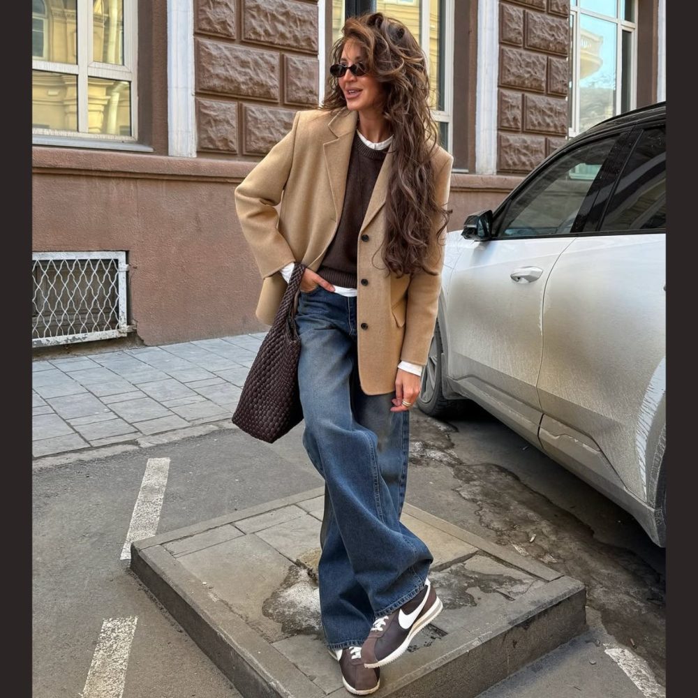 Γυναίκα με σκούρο τζιν και καφέ σακάκι