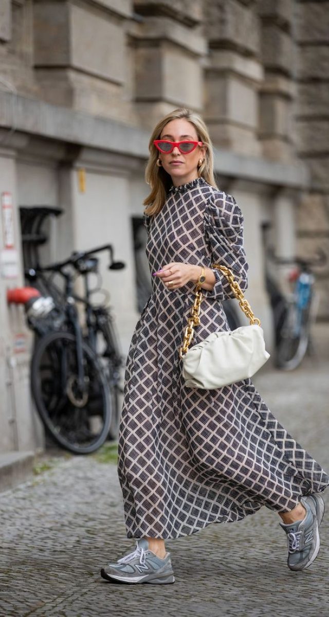 γυναίκα με μακρύ φόρεμα , σνίκερς, τσάντα και γυαλιά ηλίου