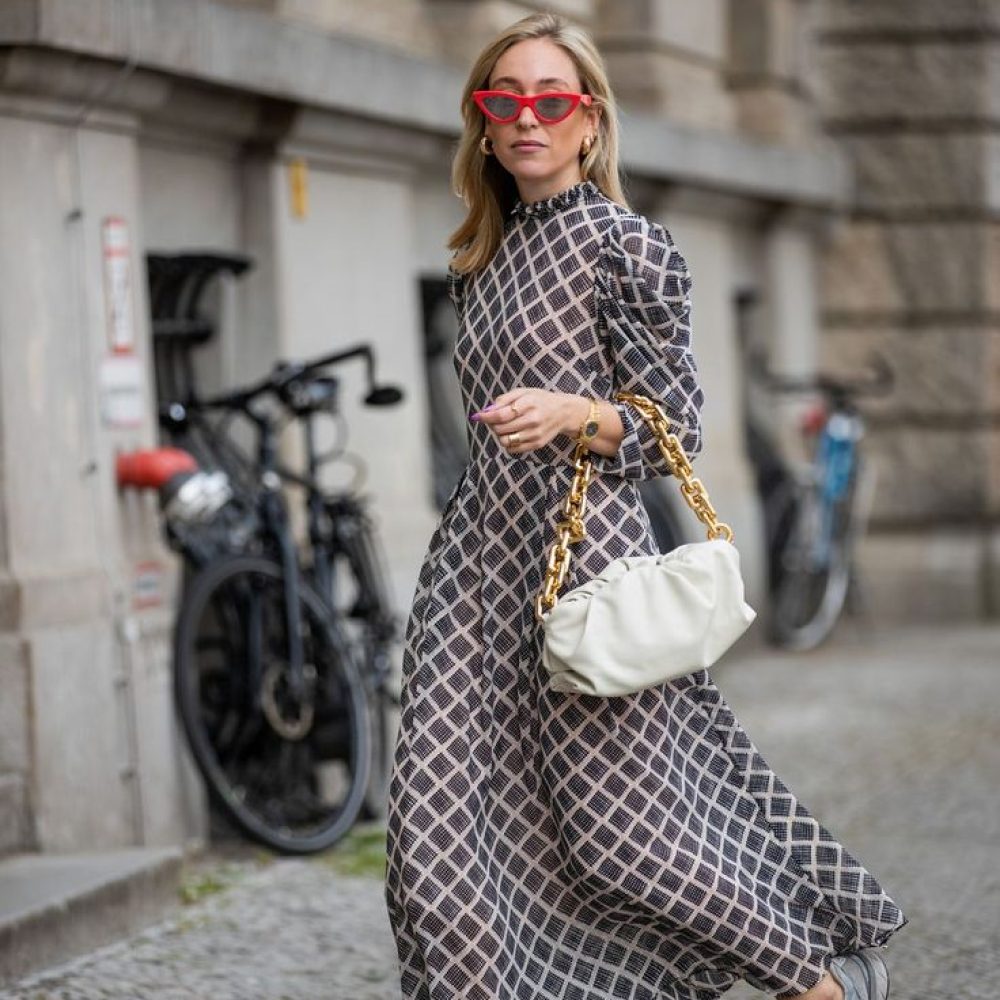 γυναίκα με μακρύ φόρεμα , σνίκερς, τσάντα και γυαλιά ηλίου