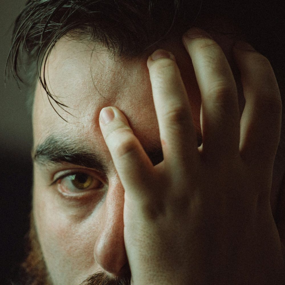 man-covering-his-face-with-his-hand-unsplash