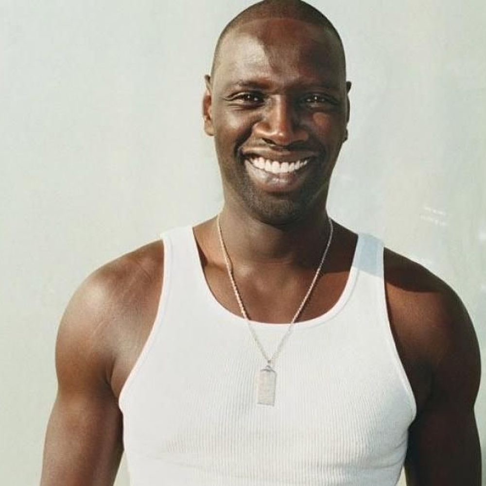 Μελαψός άντρας με λευκό φανελάκι και πλατύ χαμόγελο