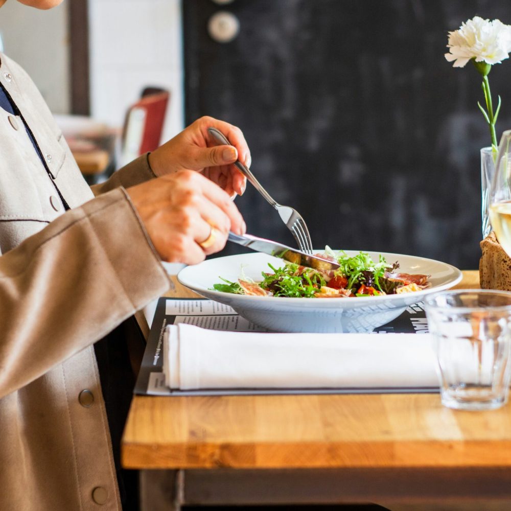 Άνθρωπος τρώει σαλάτα σε τραπέζι