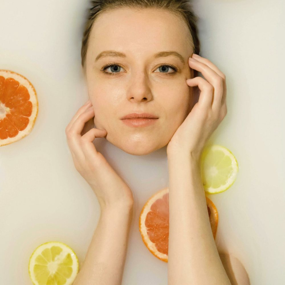 κοπέλα με πορτοκάλια και λεμόνια σε φωτογράφιση για το δέρμα