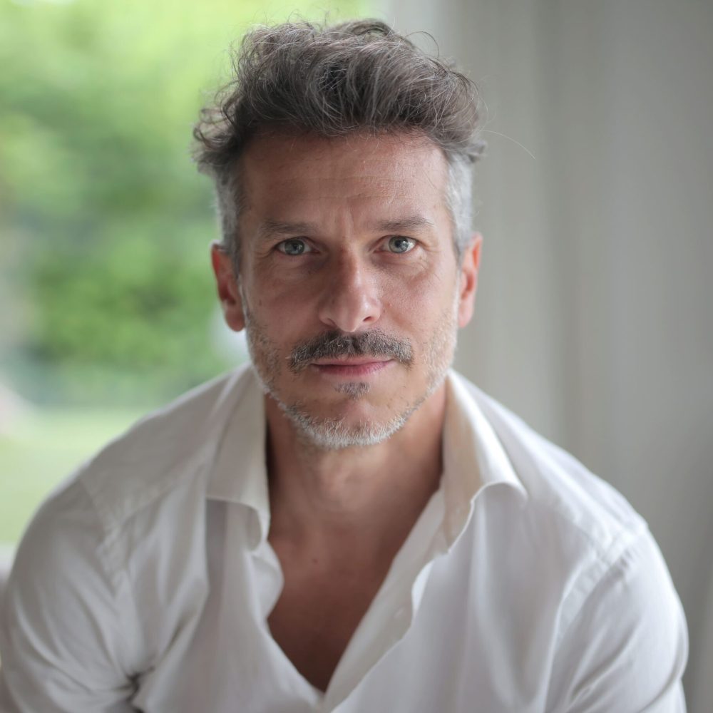 Άντρας με λευκό πουκάμισο και γκρίζα μαλλιά