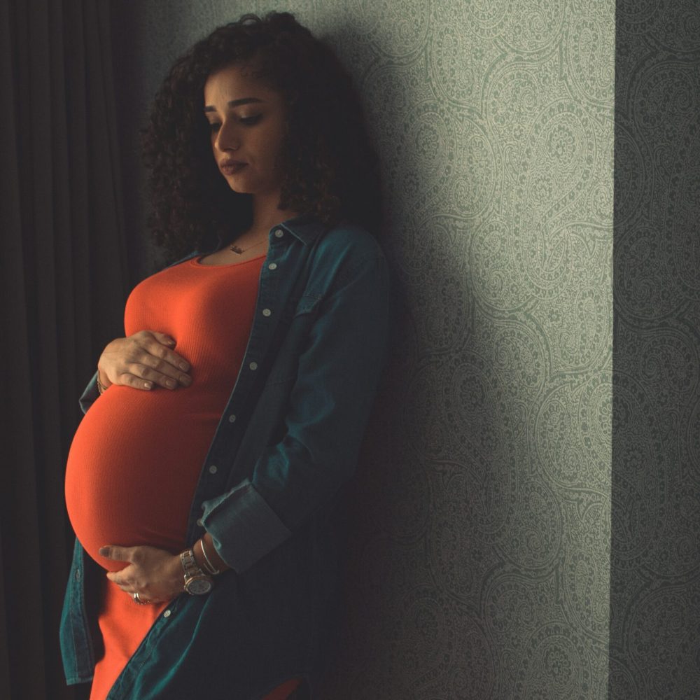 Έγκυος γυναίκα με πορτοκαλί φόρεμα