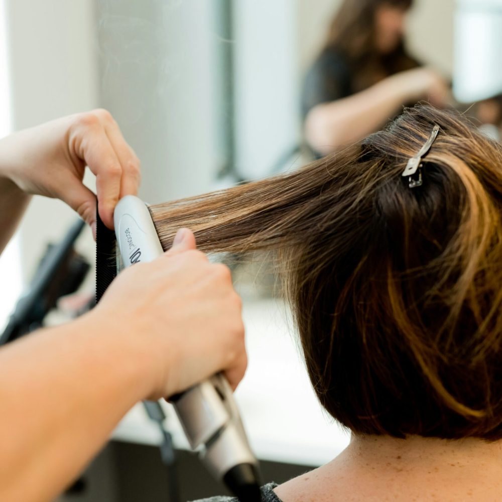 woman-blow-drying-her-hair-in-a-salon-unsplash