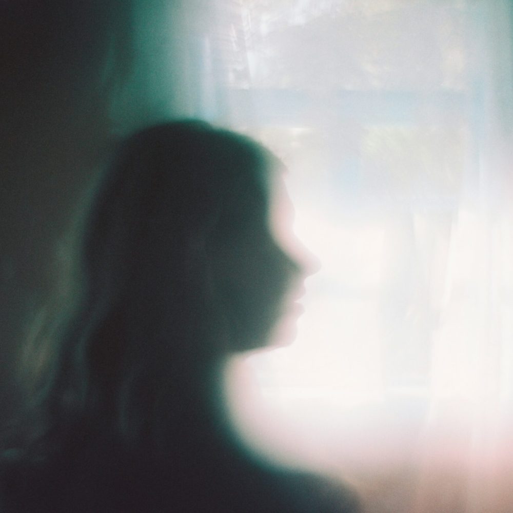 woman-standing-in-front-of-a-window-unsplash