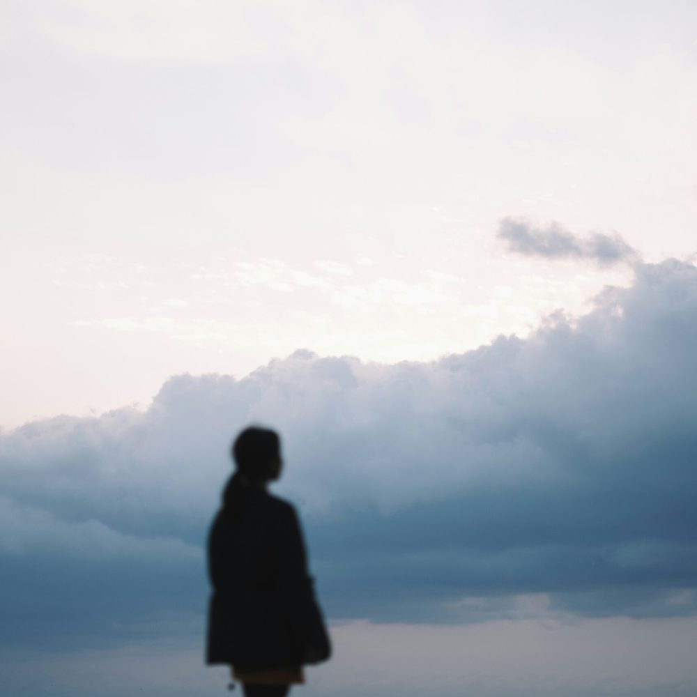 woman-under-gloomy-clouds-unsplash