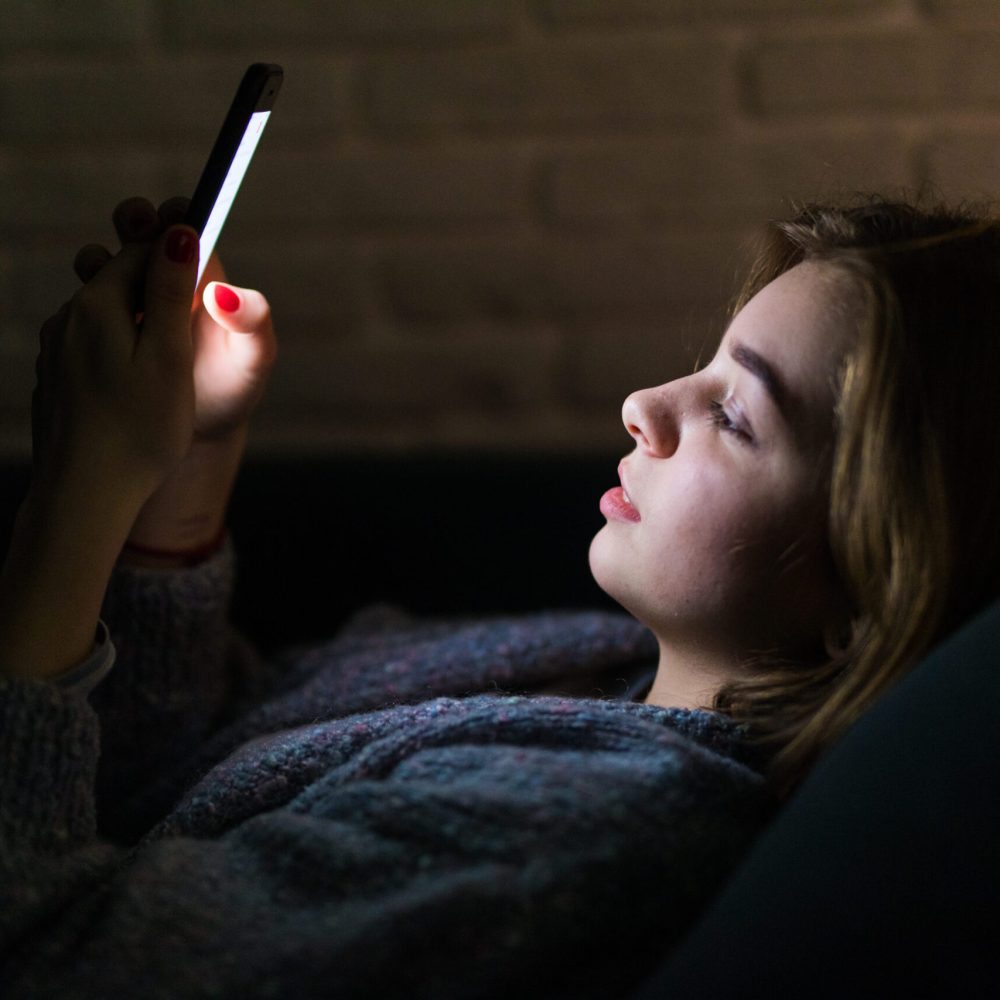young-beautiful-woman-using-smart-phone-night-bed