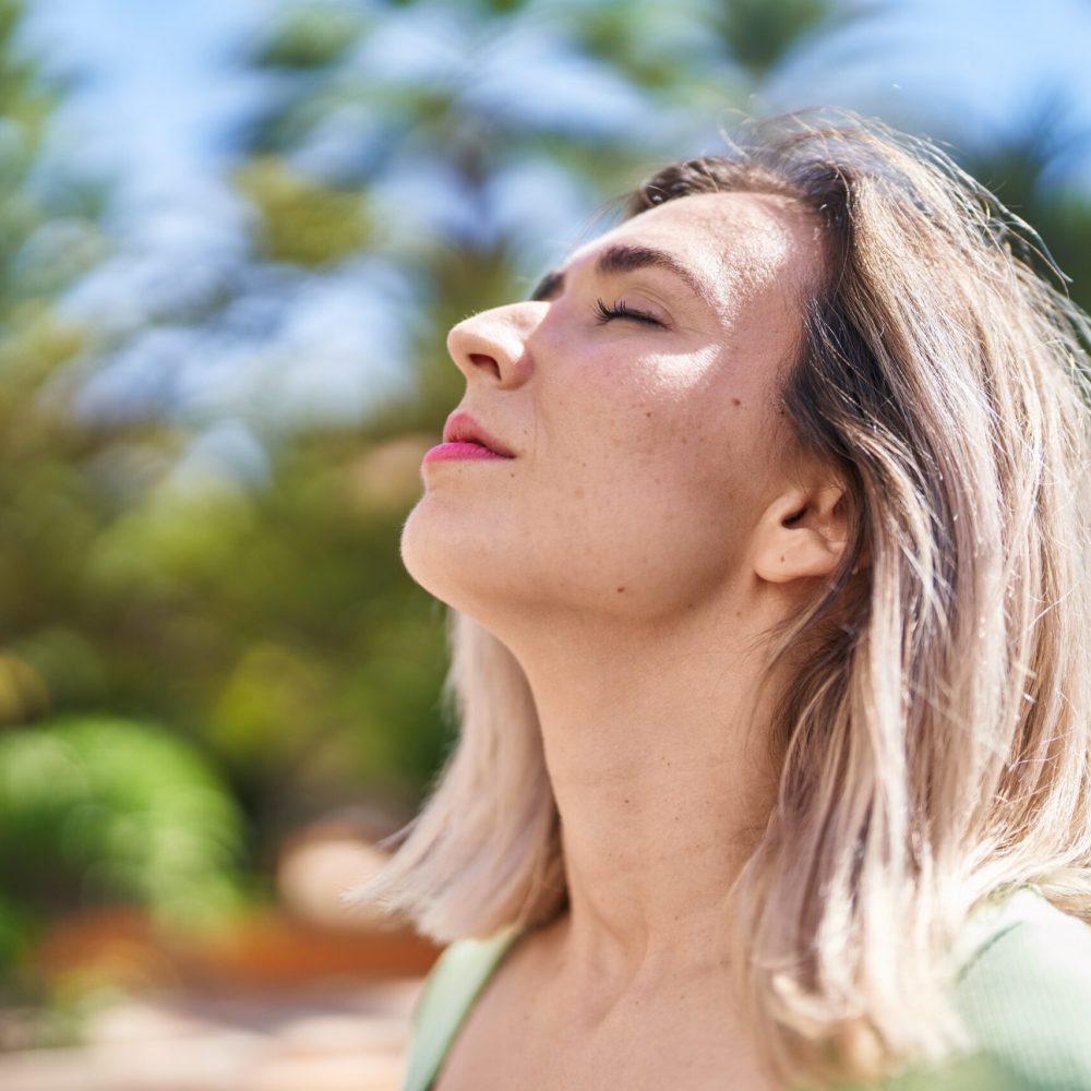 Young woman breathing at park