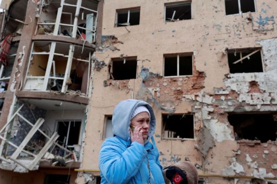 A woman stands in front of a residential building destroyed by recent shelling, as Russia's invasion of Ukraine continues, in the city of Irpin in the Kyiv region, Ukraine March 2, 2022. REUTERS/Serhii Nuzhnenko